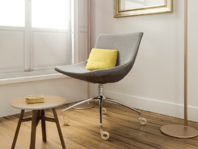 Ruedas instaladas en una silla de diseño Robby OLYM de color gris, combinando comodidad y un estilo moderno.